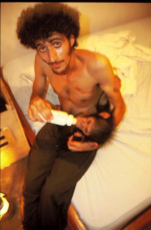 Ofir Drori feeds a bottle to Future the chimp
